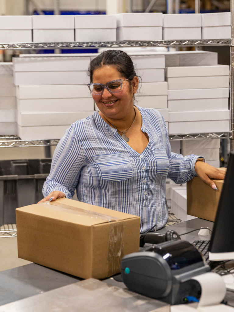 Happy woman with box and label printer