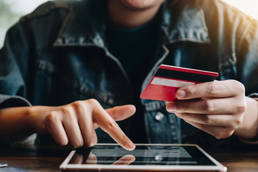 Person holding a credit card and making a Black Friday or Cyber Monday purchase on a mobile device.