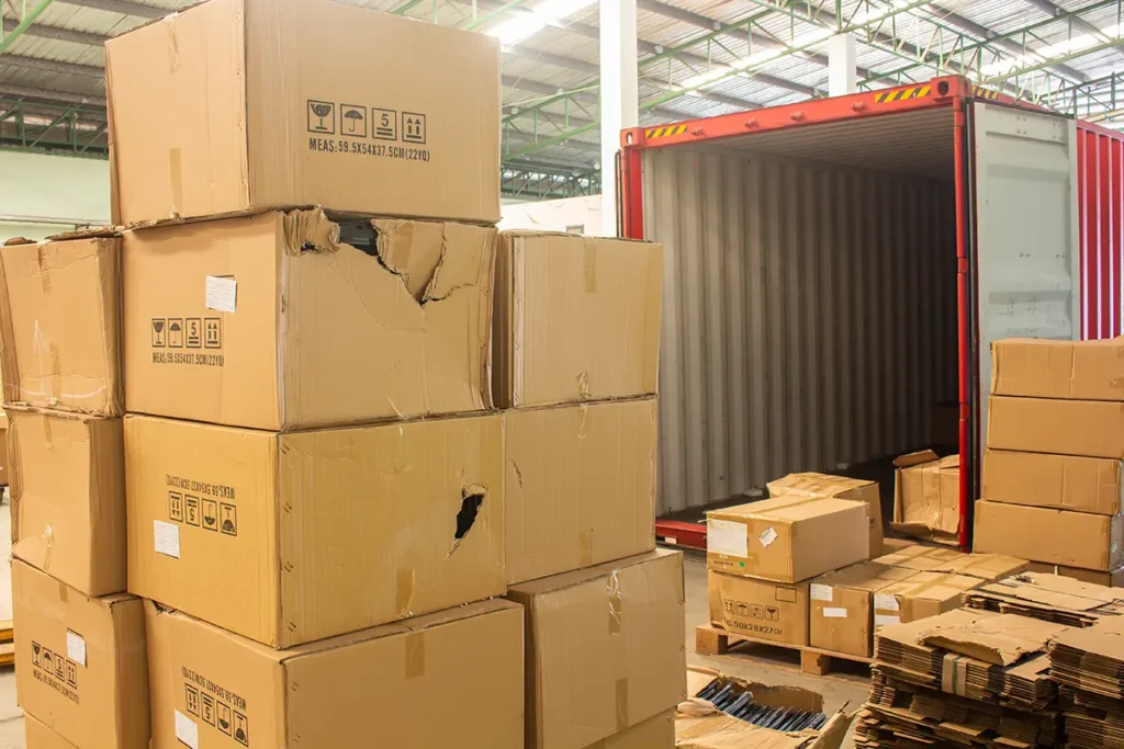 A stack of damaged parcels covered by ecommerce shipping insurance being unloaded from a truck.