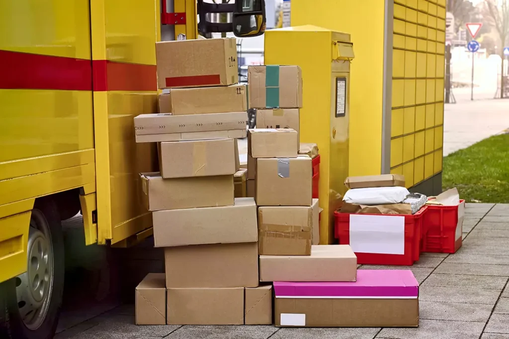 Stacks of ecommerce shipping parcels next to a delivery van for carrier pickup