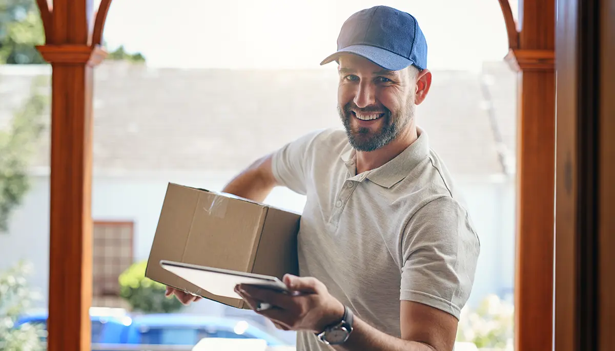 Happy man delivering a package sent with ecommerce shipping services